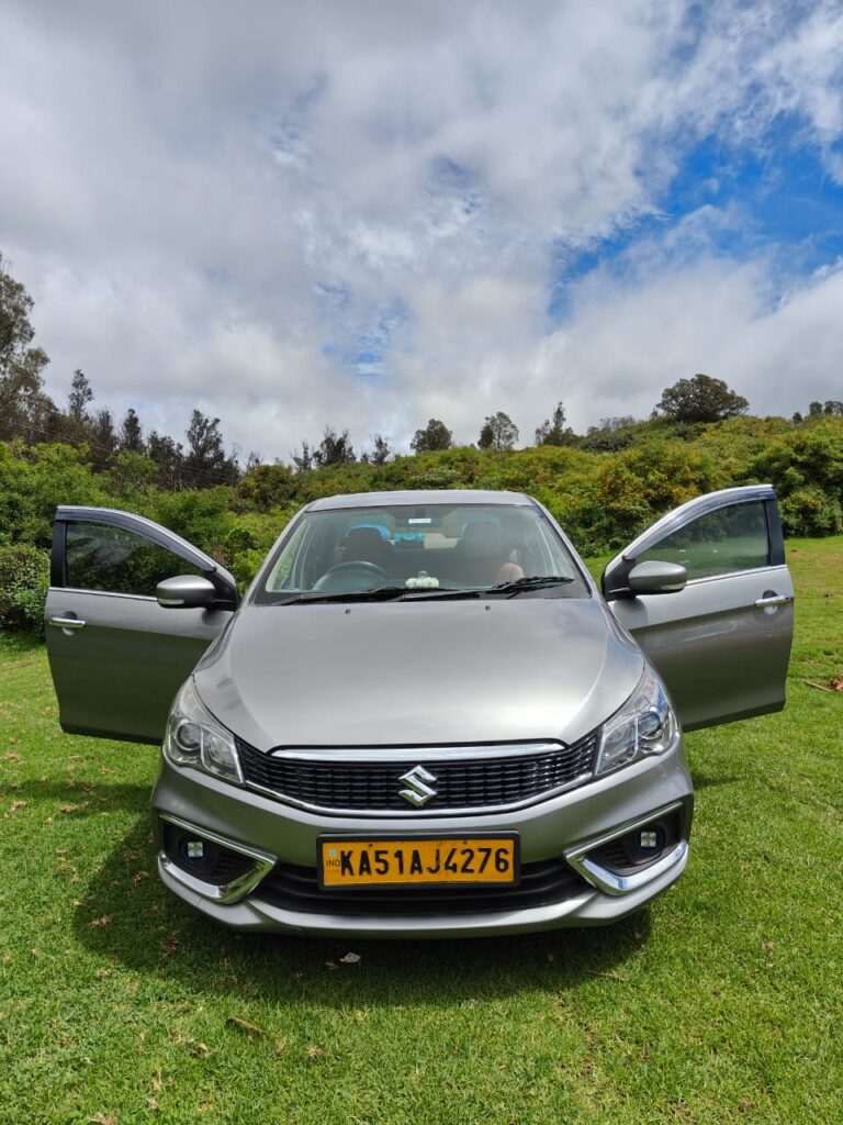 Driver (in uniform) handing over keys to a satisfied customer in Hubli.